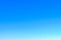 A serene view of a vibrant clear blue sky with a subtle gradient, perfect for backgrounds.